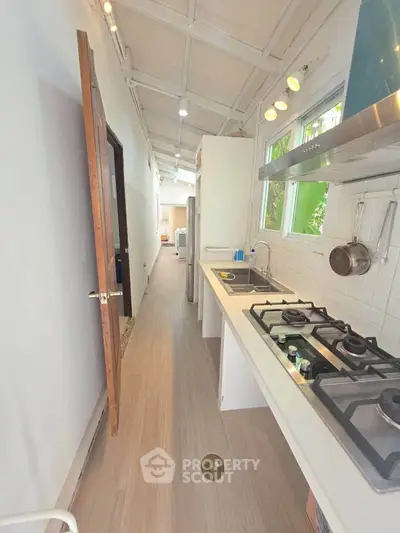Charming kitchen with gas stove and open layout, featuring modern design and natural light.
