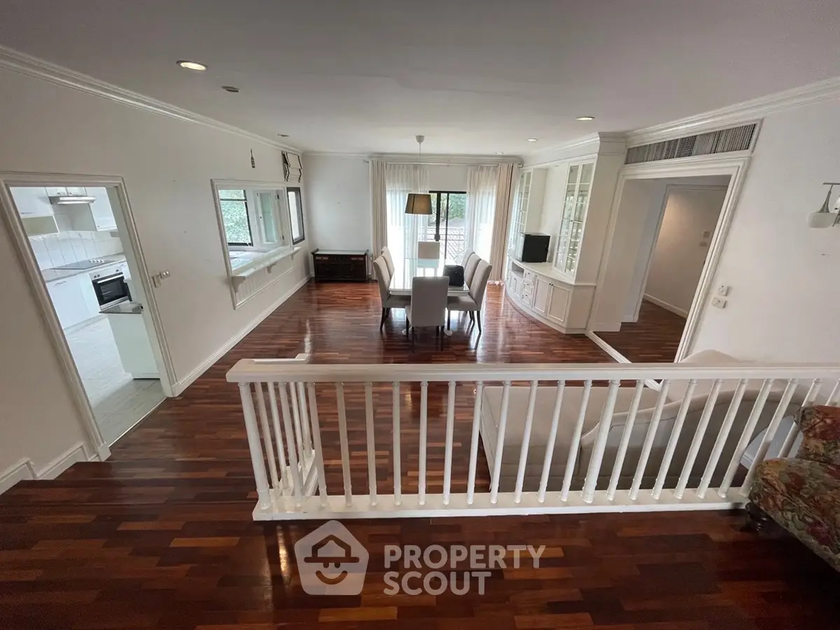 Spacious living room with elegant wooden flooring and modern dining area, perfect for family gatherings.