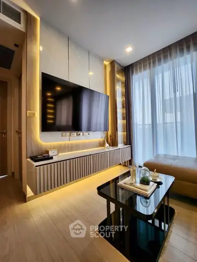 Modern living room with sleek TV setup and ambient lighting, featuring floor-to-ceiling windows and elegant decor.