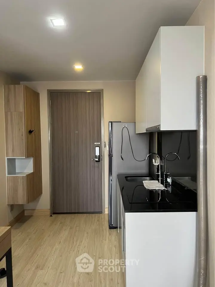 Modern kitchen with sleek cabinetry and stainless steel appliances in a compact layout.