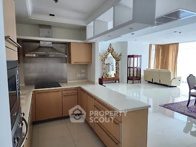 Spacious open-layout kitchen with modern appliances and elegant living room view.