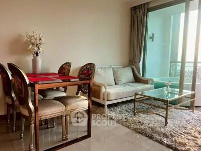 Elegant living room with plush rug, glass coffee table, and dining set near balcony.