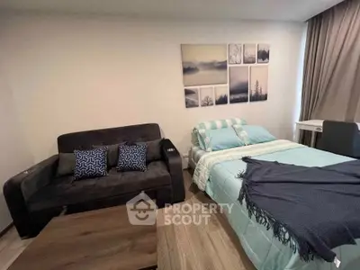 Cozy bedroom with stylish decor and comfortable seating area, perfect for relaxation.