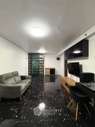 Spacious modern living room with sleek black marble flooring and stylish furniture.