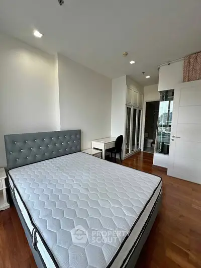 Spacious bedroom with elegant decor and ample natural light, featuring a plush bed and modern furnishings.