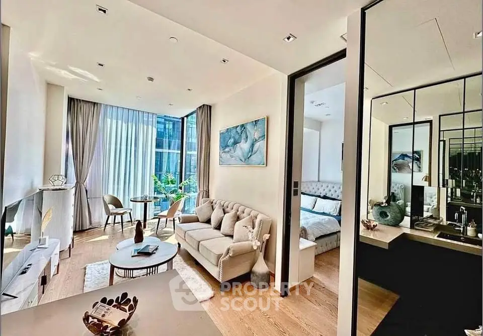 Luxurious modern living room with elegant decor and natural light, adjacent to a cozy bedroom.
