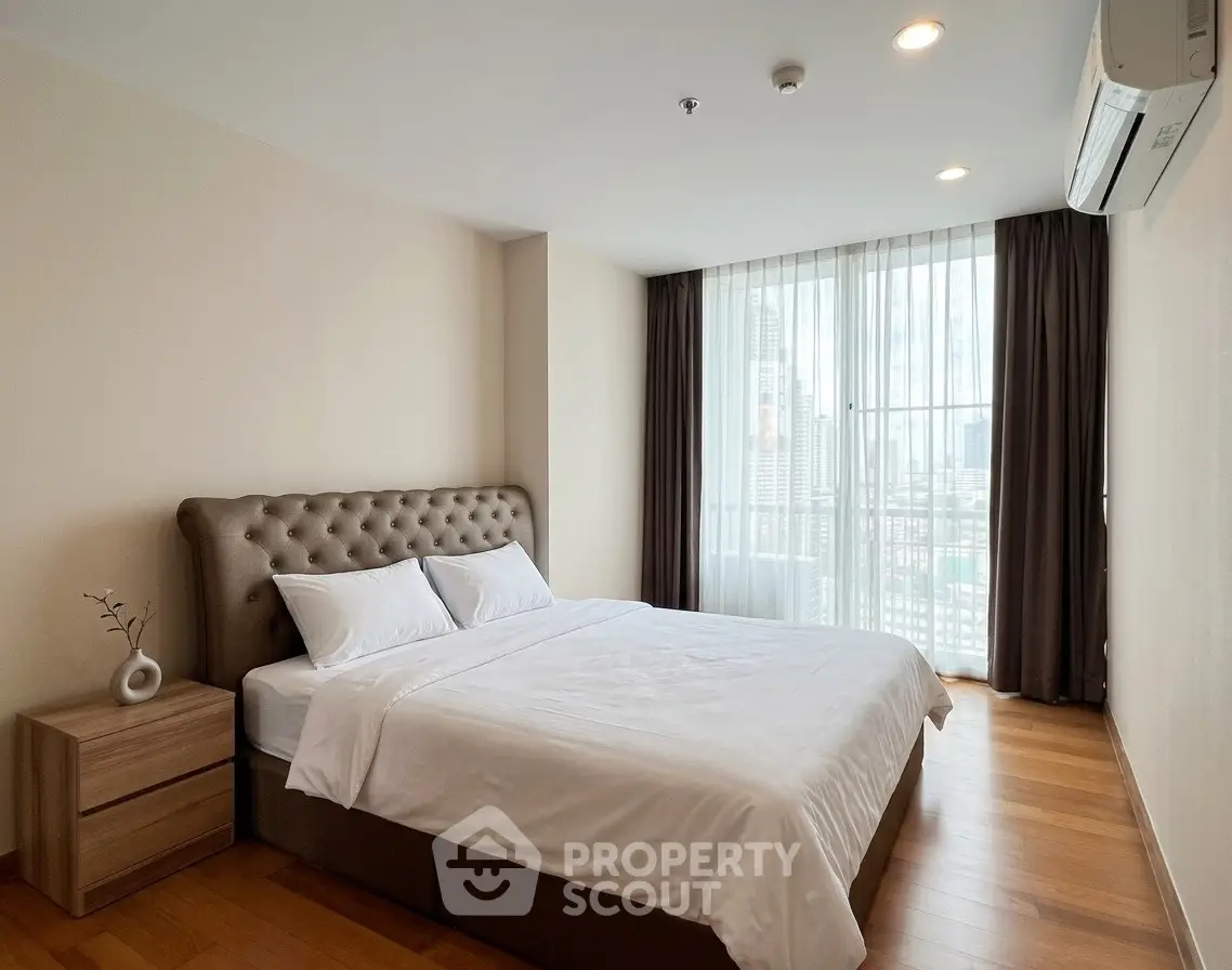 Spacious bedroom with city view, featuring a comfortable bed and modern decor.