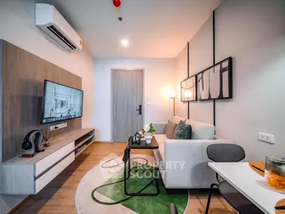 Modern living room with stylish decor and wall-mounted TV in a cozy apartment setting.
