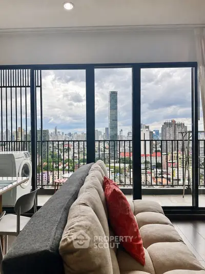 Spacious living room with stunning city view and balcony access, featuring modern furniture and natural light.