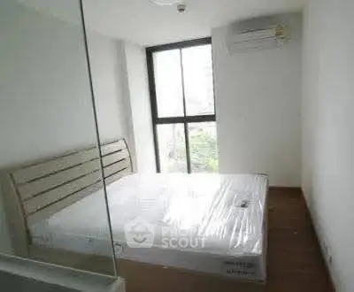 Cozy bedroom with large window and air conditioning in modern apartment.
