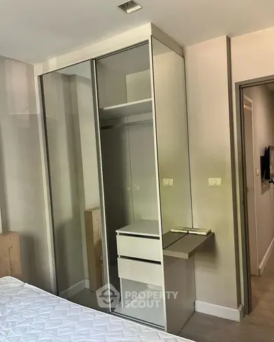 Modern bedroom with sleek mirrored wardrobe and cozy ambiance