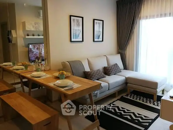 Modern living room with stylish decor and natural light, featuring a cozy sofa and dining area.