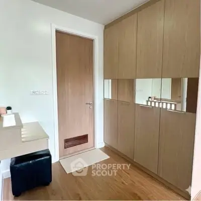 Modern bedroom with sleek wooden wardrobe and stylish door