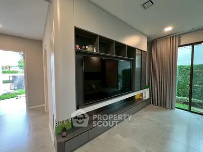 Modern living room with sleek built-in entertainment center and large windows.