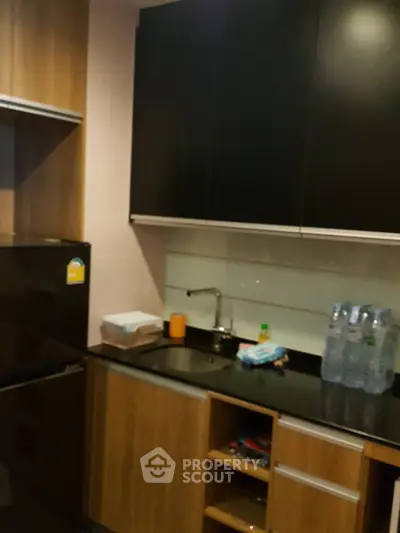 Modern kitchen with sleek cabinets and black countertop in a stylish apartment.