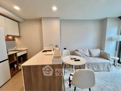 Modern open-layout kitchen and living room with sleek furniture and neutral tones.