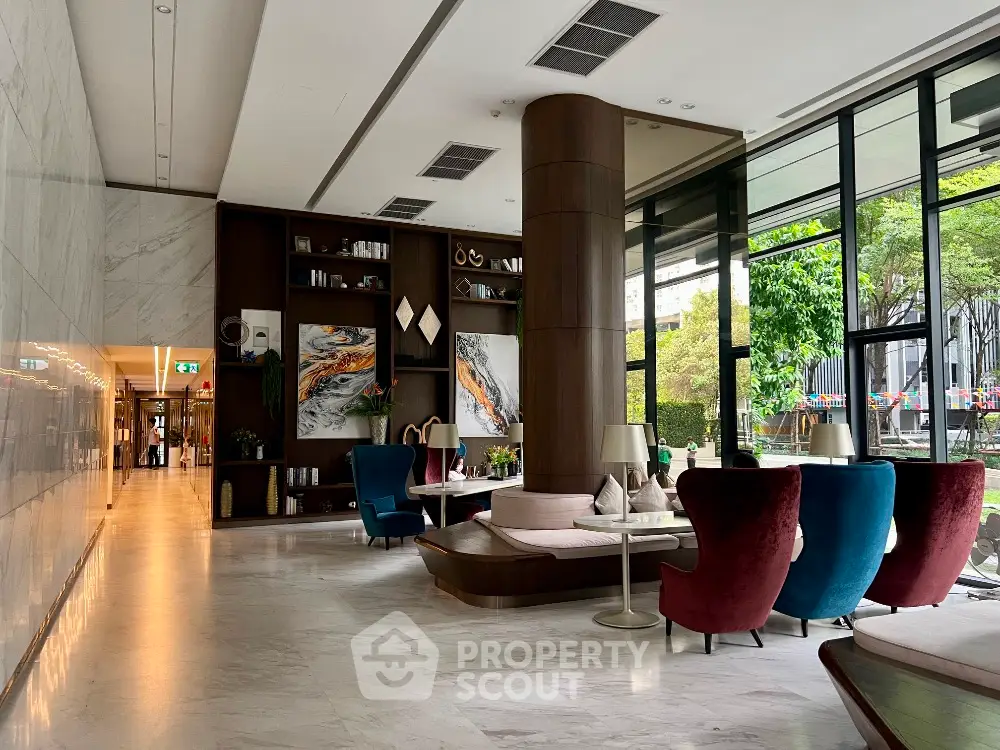 Luxurious modern living area with elegant seating and large windows overlooking greenery.