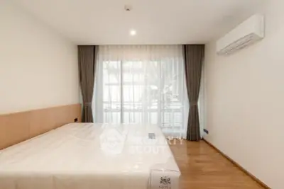 Spacious bedroom with large window and modern air conditioning unit, perfect for comfort and relaxation.