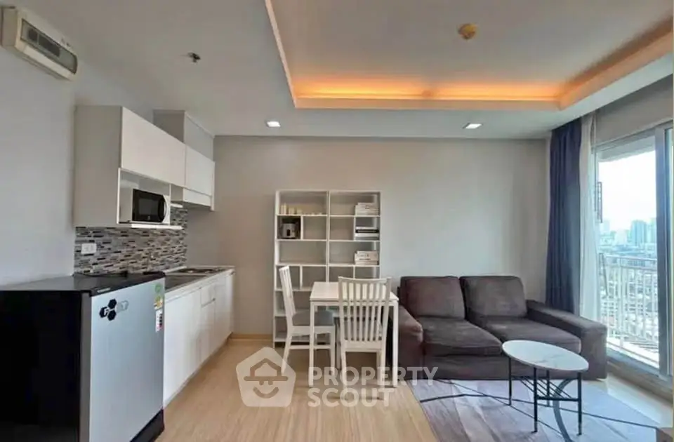 Modern open-layout living room with kitchen, featuring sleek furniture and city view balcony.