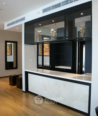 Modern interior with sleek built-in shelving and elegant wood flooring, perfect for stylish living.