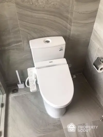 Modern bathroom with sleek toilet and gray tile design