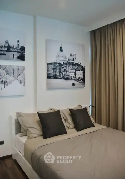 Modern bedroom with stylish decor and elegant wall art, featuring a cozy bed and neutral tones.