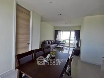 Spacious living room with dining area and balcony view in modern apartment.