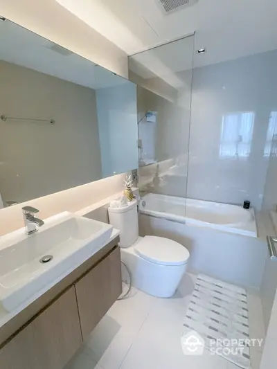 Modern bathroom with sleek fixtures and a bathtub in a contemporary apartment.