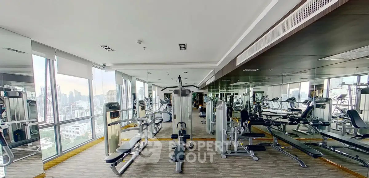 Spacious modern gym with city view in luxury residential building