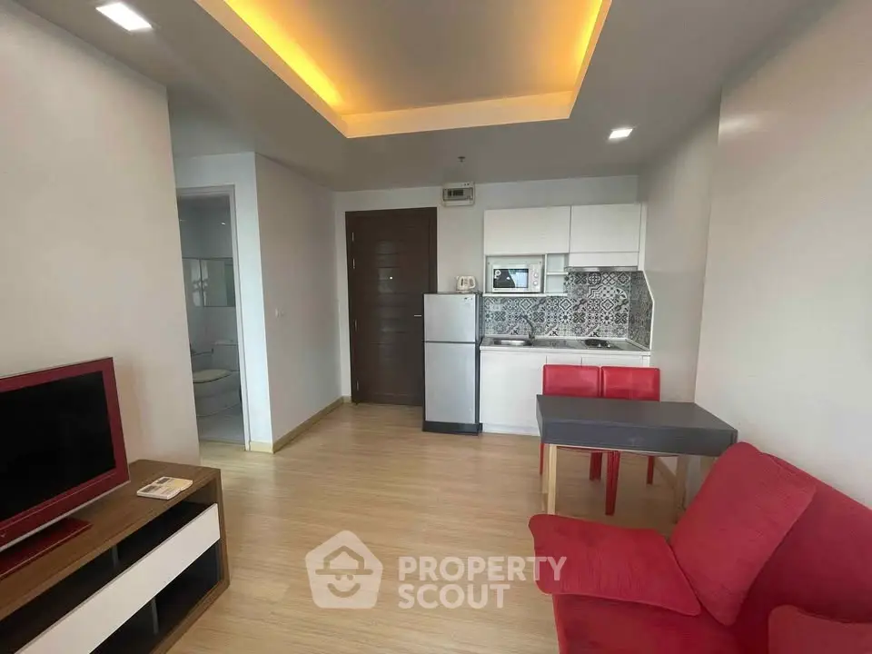 Modern apartment interior with open kitchen and red sofa