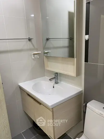 Modern bathroom with sleek sink and mirror in contemporary apartment.