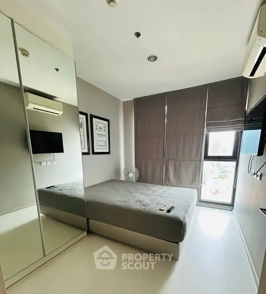 Modern bedroom with mirrored wardrobe and natural light