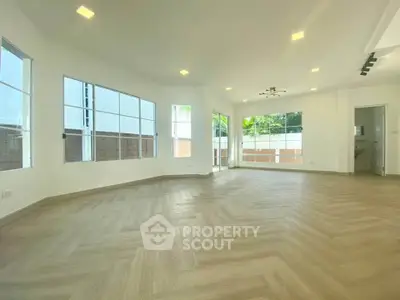 Spacious and bright living room with large windows and modern flooring