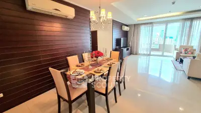 Luxurious open-plan living and dining area with elegant decor and city view.