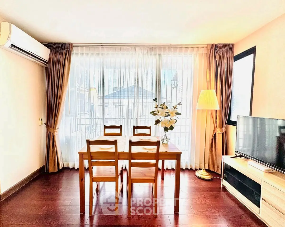 Bright living room with wooden dining set and large window, perfect for cozy gatherings.
