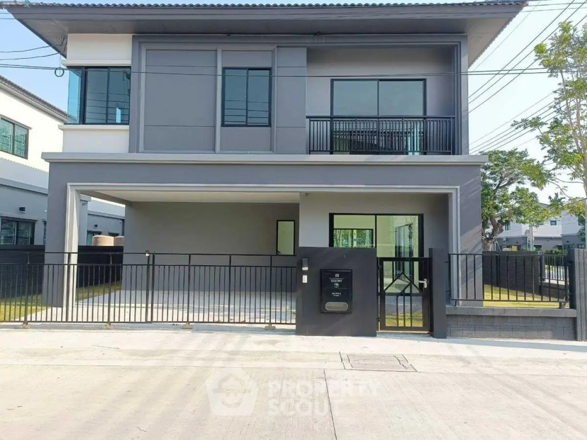 Modern two-story house with sleek design and spacious driveway in a suburban neighborhood.