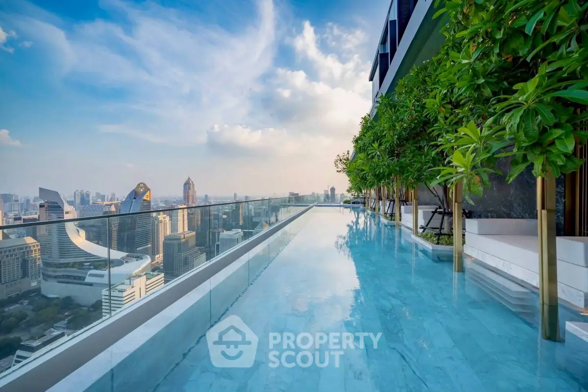 Luxurious rooftop pool with stunning city skyline view and lush greenery.