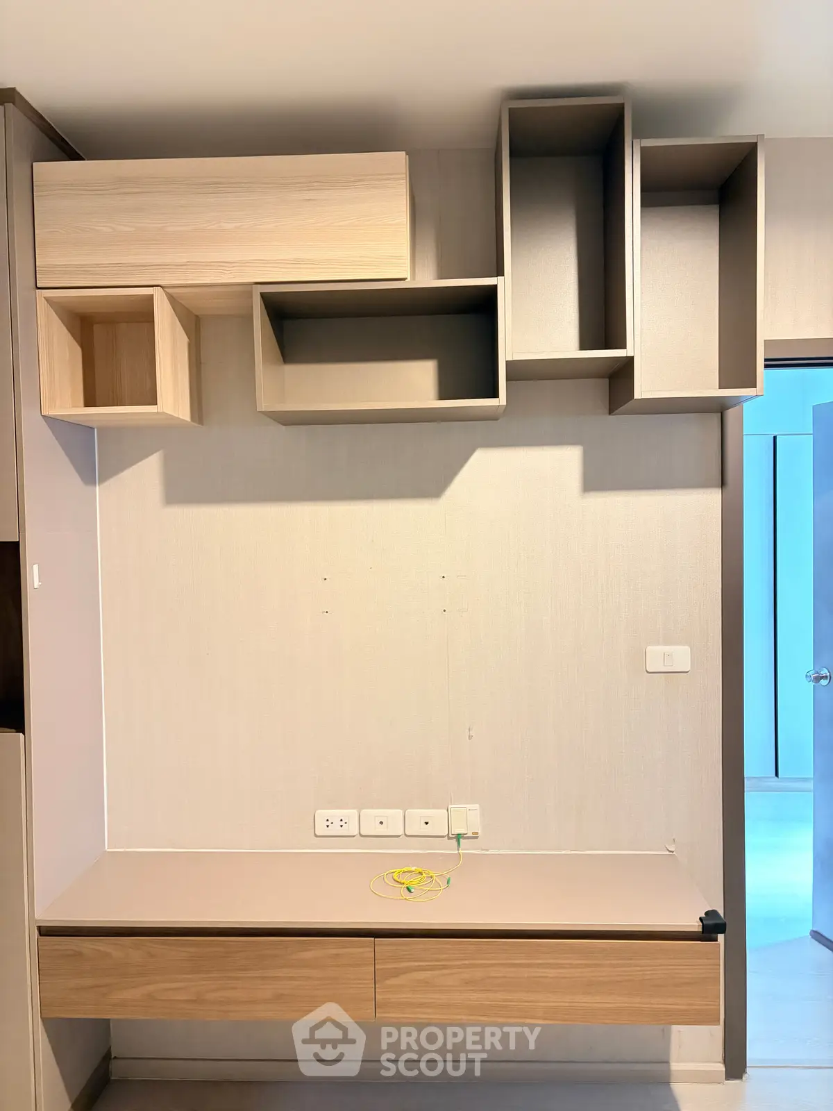Modern interior with stylish wall-mounted storage and sleek desk in a contemporary apartment.