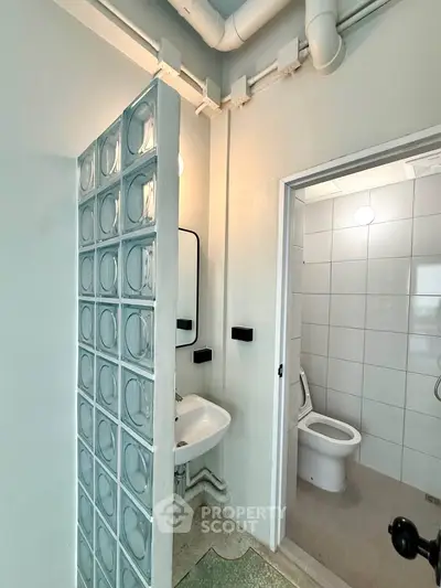 Modern bathroom with glass block partition and sleek fixtures