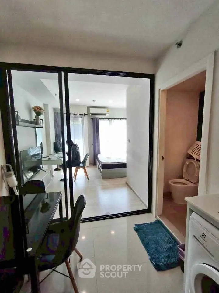 Modern apartment interior with open layout, featuring a cozy living area and adjacent bedroom.