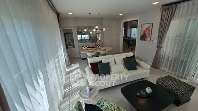 Spacious modern living room with elegant decor and large windows offering natural light.
