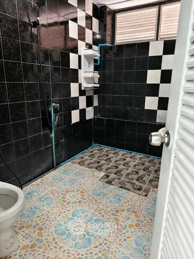 Modern bathroom with black and white tiles and unique floor design