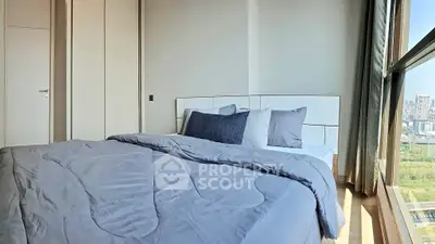 Modern bedroom with large window offering stunning city view