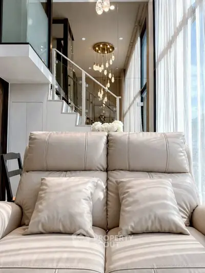 Luxurious modern living room with elegant leather sofa and stunning chandelier lighting