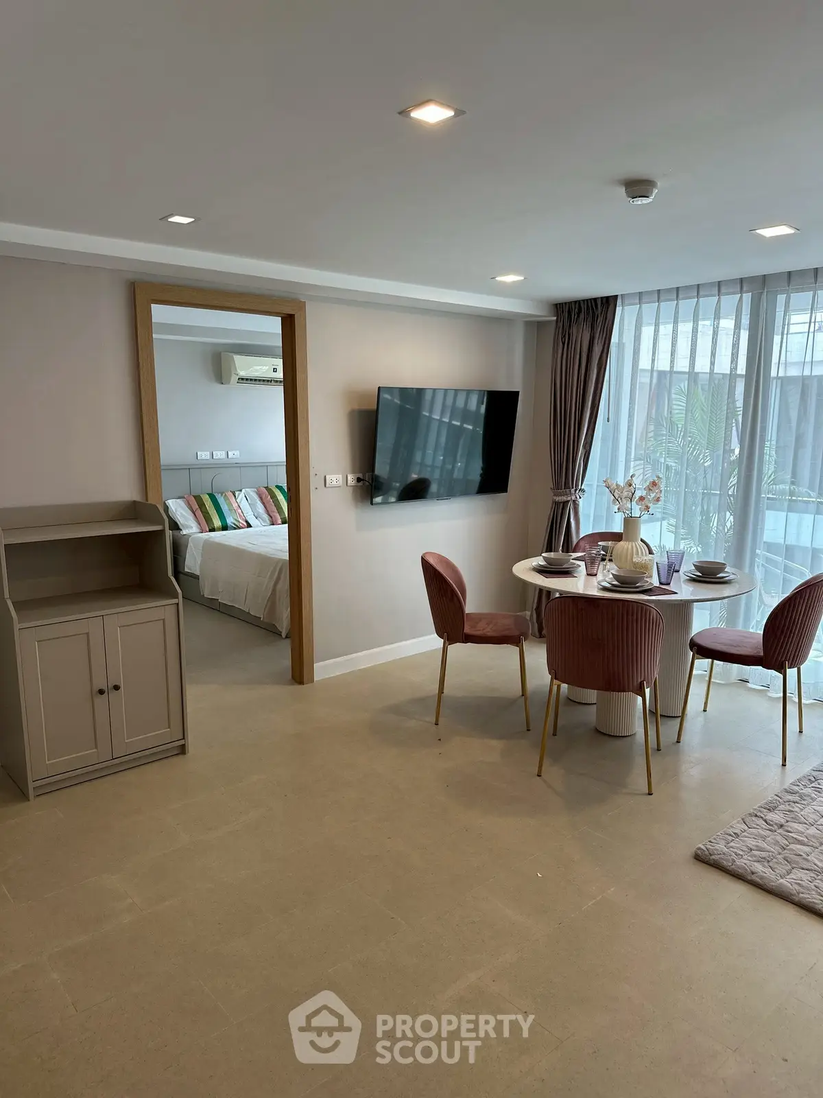 Modern open-plan living room with dining area and bedroom view