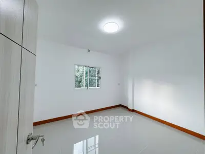 Bright empty room with window and tiled floor, ready for customization.