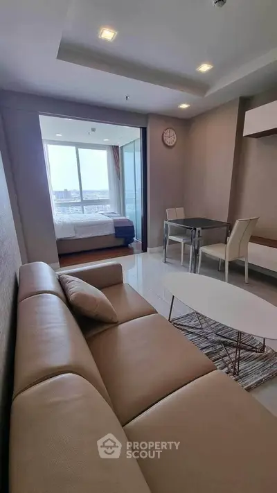 Modern living room with leather sofa and dining area, featuring a view of the city through large windows.