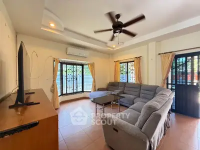 Spacious living room with modern sectional sofa and ceiling fan