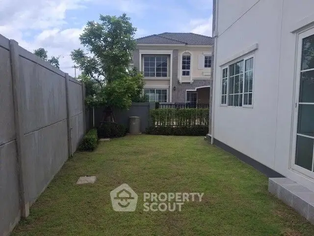 Spacious backyard with lush lawn and modern house exterior