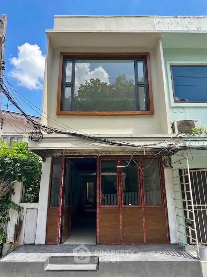 Modern two-story building with large windows and sleek facade, perfect for urban living.